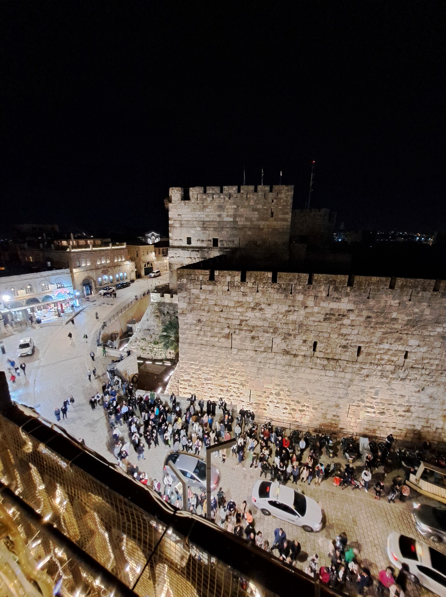 Tower of David citadel at night, Jerusalem old city, with crowds gathered below the ancient stone walls